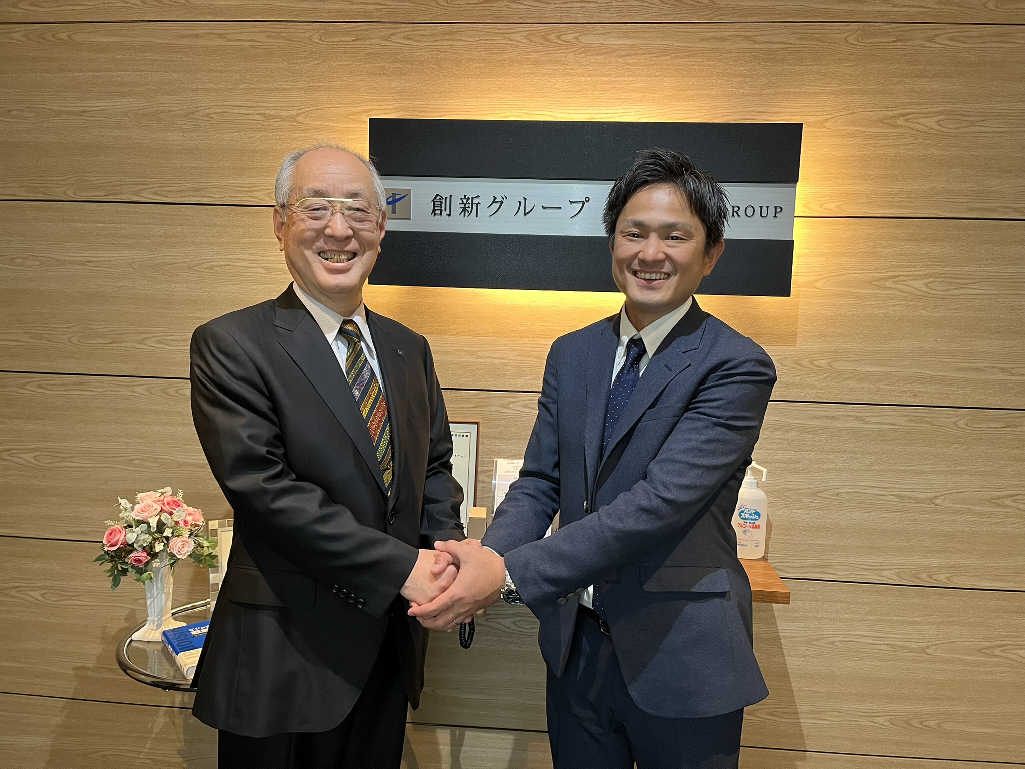 創新グループの事業承継を象徴する握手の写真